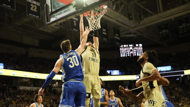 Feb 24, 2024; Winston-Salem, North Carolina, USA; Wake Forest Demon Deacons forward Andrew Carr (11) dunks the ball against Duke Blue Devils center Kyle Filipowski (30) during the first half at Lawrence Joel Veterans Memorial Coliseum.